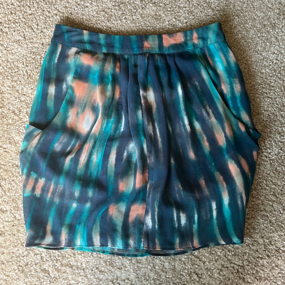 Teal with a splash of peach colored above the knee (mini if long legs) skirt
